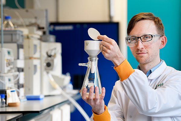 Lech Milroy, UD Chemical Biology, Dept of Biomedical Engineering, TU Eindhoven, demonstrating the simple filtration principle for simple scaled-up production of pure Z-endoxifen. In the background a labour-intensive high pressure setup to produce the same in low quantities.