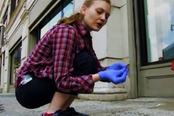 New York artist Heather Dewey-Hagborg bends down to collect a freshly discarded cigarette butt specimen from the sidewalk. It can be used to re-create an artistic recreation of the anonymous New Yorker's head.